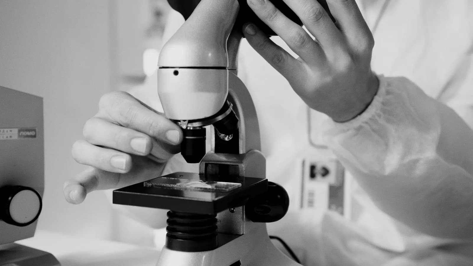 Researcher examining a sample under a laboratory microscope